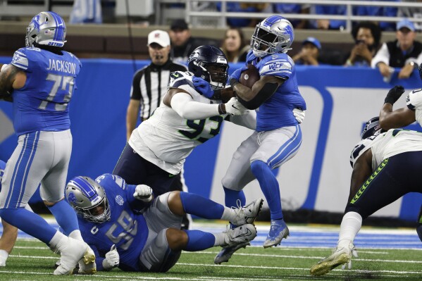 Detroit Lions running back David Montgomery (5) is tackled by Seattle Seahawks defensive tackle Cameron Young (93) during the first half of an NFL football game, Sunday, Sept. 17, 2023, in Detroit. (AP Photo/Duane Burleson)
