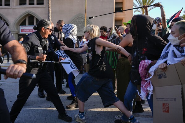 Police clash with pro-Palestinian demonstrators at the Shrine Auditorium, where a commencement ceremony for graduates from Pomona College was being held Sunday, May 12, 2024, in Los Angeles. (AP Photo/Ryan Sun)