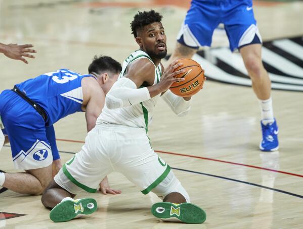 Oregon forward Quincy Guerrier, right, looks to pass the ball from next to BYU's Alex Barcello during the second half of an NCAA college basketball game in Portland, Ore., Tuesday, Nov. 16, 2021. (AP Photo/Craig Mitchelldyer)