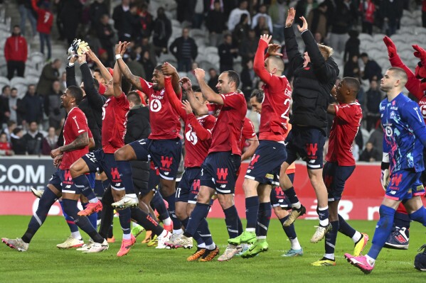 Lille players celebrate their victory at the French League One soccer match between Lille and Marseille at the Pierre Mauroy stadium in Villeneuve d'Ascq, northern France, Friday, April 5, 2024. (AP Photo/Matthieu Mirville)