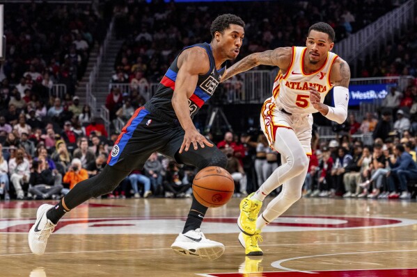 Detroit Pistons guard Jaden Ivey (23) dribbles the ball while guarded by Atlanta Hawks guard Dejounte Murray (5) during the first half of an NBA basketball game, Wednesday, April 3, 2024, in Atlanta. (AP Photo/Jason Allen)
