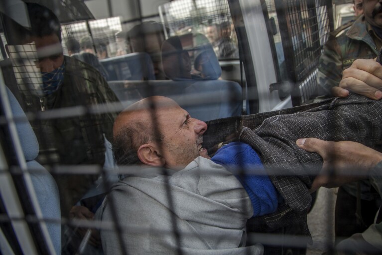 Indian policemen detain Jammu and Kashmir state's lawmaker, Engineer Abdul Rashid Sheikh, after he was stopped from offering prayers at the Grand Mosque in Srinagar, Indian controlled Kashmir, Friday, Nov. 18, 2016. Sheikh was detained after he and his supporters tried offering Friday prayers at the mosque. Indian government has banned people from offering prayers inside the mosque on Fridays for the past several weeks. (AP Photo/Dar Yasin)