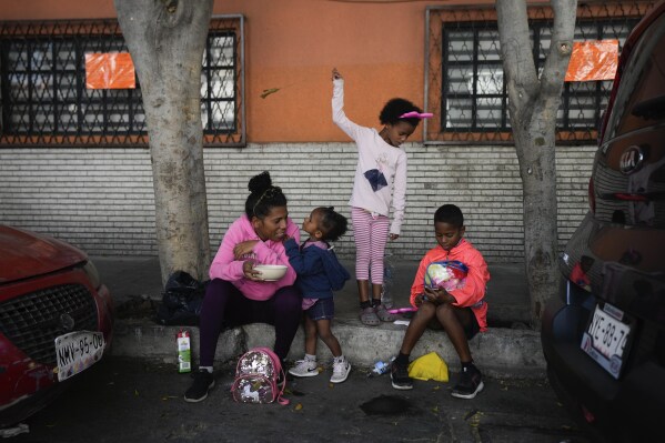 Una familia de inmigrantes venezolanos desayuna junto a las vías del tren bordeadas por tiendas de campaña improvisadas en la Ciudad de México, el martes 26 de marzo de 2024. (AP Foto/Fernando Llano)