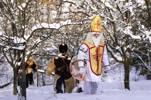 FILE - Revelers take part in a traditional St. Nicholas procession in the village of Lidecko, Czech Republic, Monday, Dec. 4, 2023. Nicholas was a fourth century Catholic bishop from the Mediterranean port city of Myra (in modern-day Turkey). “Much of the rest is legend. There’s not really a lot of hard historical evidence about St. Nicholas,” said the Rev. Nicholas Ayo, author of “Saint Nicholas in America: Christmas Holy Day and Holiday.” (AP Photo/Petr David Josek, File)