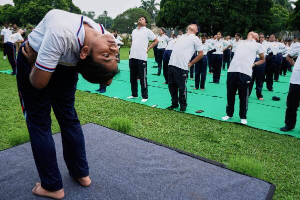 People follow a posture by an instruction as they perform yoga on International Yoga Day at Victoria Memorial compound, in Kolkata, India, Saturday, June 21, 2025. (AP Photo/Bikas Das)