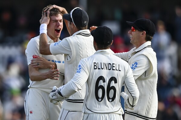 New Zealand's Ben Sears, left, is congratulated by teammates after taking the wicket of Australia's Cam Green, right, on day three of the second cricket test between New Zealand and Australia in Christchurch, New Zealand, Sunday, March 10, 2024. (John Davidson/Photosport via AP)