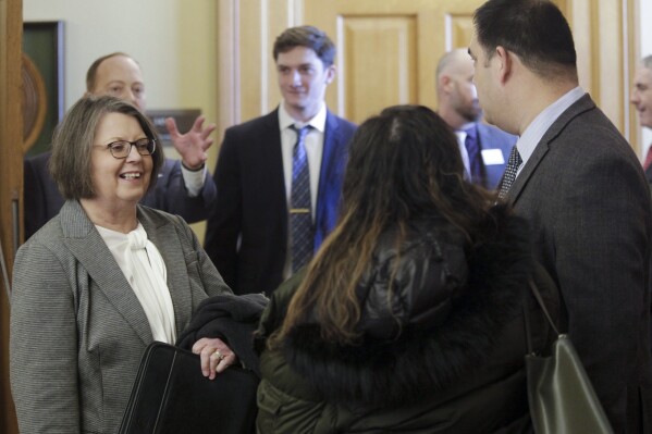 Kansas Supreme Court Chief Justice Marla Luckert, left, chats with spectators who have gathered for a joint meeting of the Kansas House and Senate Judiciary committees, Tuesday, Jan. 16, 2024, at the Statehouse in Topeka, Kan. Luckert is telling lawmakers that the court system needs at least $2.6 million in additional funds to recover from a cyberattack in October 2023. (AP Photo/John Hanna)