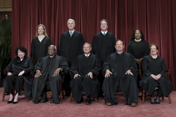 FILE - Members of the Supreme Court sit for a new group portrait following the addition of Associate Justice Ketanji Brown Jackson, at the Supreme Court building in Washington, on Oct. 7, 2022. Bottom row, from left, Associate Justice Sonia Sotomayor, Associate Justice Clarence Thomas, Chief Justice of the United States John Roberts, Associate Justice Samuel Alito, and Associate Justice Elena Kagan. Top row, from left, Associate Justice Amy Coney Barrett, Associate Justice Neil Gorsuch, Associate Justice Brett Kavanaugh, and Associate Justice Ketanji Brown Jackson. The core issue being debated before the Supreme Court on April 25, 2024, boils down to this: Whether a former president is immune from prosecution for actions taken while in office — and, if so, what is the extent of the immunity? (AP Photo/J. Scott Applewhite)