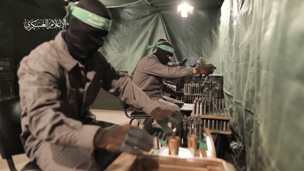 This image from video posted by Hamas on Dec. 20, 2023, purports to show Hamas militants using machining equipment to make their own domestic copies of the AM-50 Sayyad, an Iranian-made a sniper rifle that fires a .50- caliber round powerful enough to punch through up to an inch of steel. Experts interviewed by The Associated Press said it would be nearly impossible for Hamas to manufacture a safe and accurate sniper rifle using the rudimentary equipment shown in the video. Watermark at upper left reads “military media.” (Hamas via AP)