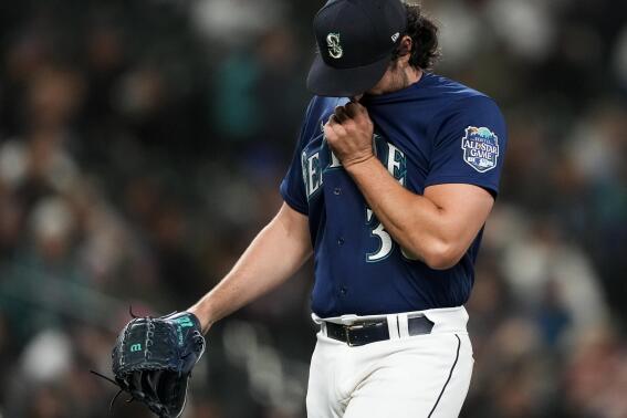 Seattle Mariners starting pitcher Robbie Ray wipes his face as he walks off of the field after being removed during the fourth inning of the team's baseball game against the Cleveland Guardians on Friday, March 31, 2023, in Seattle. (AP Photo/Lindsey Wasson)