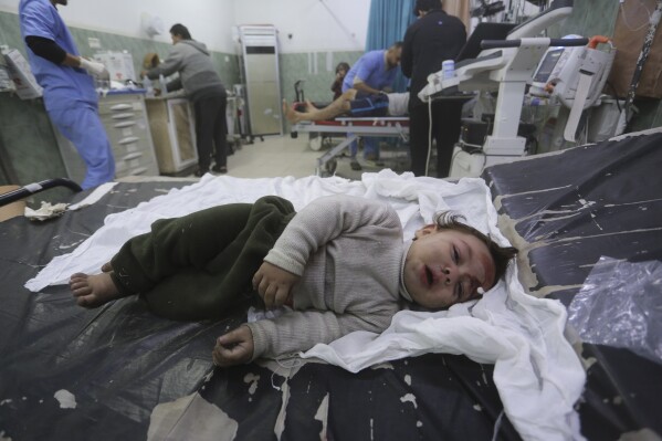 A Palestinian child wounded in the Israeli bombardment of the Gaza Strip is brought to a hospital in Rafah on Tuesday, Dec. 12, 2023. (AP Photo/Hatem Ali)