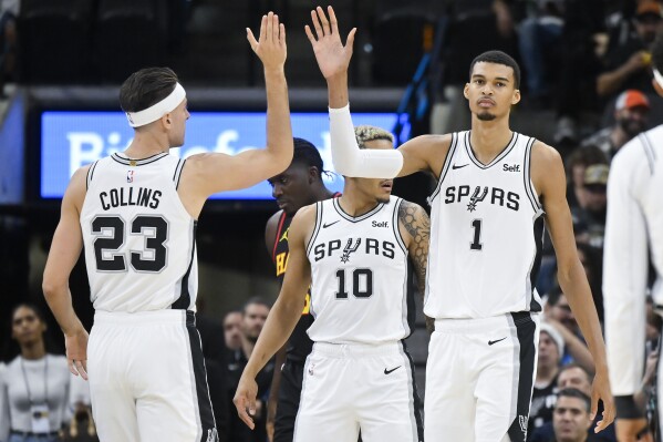 San Antonio Spurs' Victor Wembanyama (1) and Zach Collins (23) celebrate a play during the first half of the team's NBA basketball game against the Atlanta Hawks, Thursday, Nov. 30, 2023, in San Antonio. (AP Photo/Darren Abate)