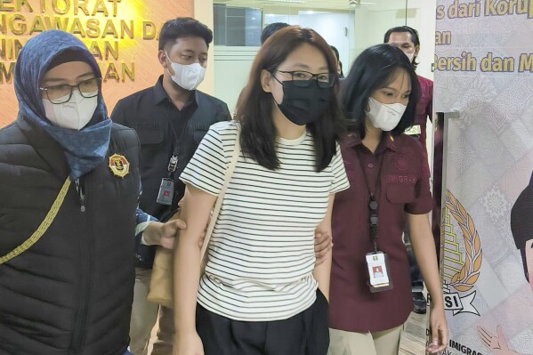 In this photo released by the Directorate General of Immigration of Indonesia's Justice and Human Rights Ministry (Ditjen Imigrasi), Alice Guo, center, a dismissed Philippine town mayor accused in Manila of helping establish an illegal online gaming and scam center and evading an investigation by the Philippine Senate is escorted by immigration officers prior to her deportation, in Jakarta, Indonesia, Thursday, Sept. 5, 2024. (Ditjen Imigrasi via AP)