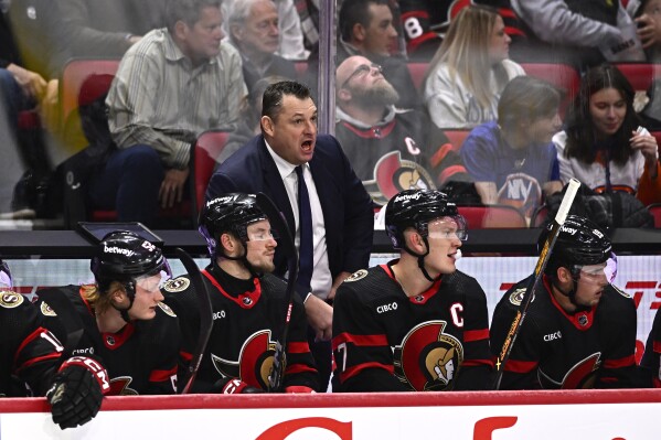 Ottawa Senators head coach D.J. Smith, center, stands behind the bench during first-period NHL hockey game action against the New York Islanders in Ottawa, Ontario, Friday, Nov. 24, 2023. (Justin Tang/The Canadian Press via AP)