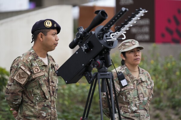 Airmen stand guard next to a drone shield on the perimeters of the Ministry of Culture, the venue for the annual Asia-Pacific Economic Cooperation (APEC) summit in Lima, Peru, Friday, Nov. 15, 2024. (AP Photo/Fernando Vergara)