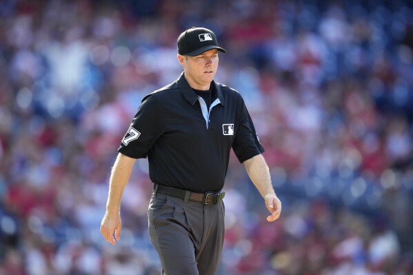 First base umpire Lew Williams walks the field after a video review during the third inning of the first baseball game in a doubleheader between the Philadelphia Phillies and the Washington Nationals, Tuesday, Aug. 8, 2023, in Philadelphia. (AP Photo/Matt Slocum)