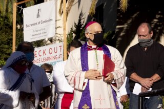San Francisco's Archbishop Salvatore Cordileone conducts an exorcism Saturday, Oct. 17, 2020, outside of Saint Raphael Catholic Church in San Rafael, Calif., on the spot where a statue of St. Junipero Serra was toppled during a protest on Oct. 12. (Jessica Christian/San Francisco Chronicle via AP)