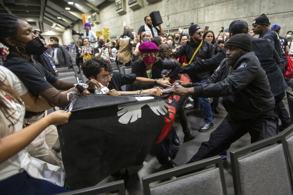 CORRECTS LOCATION TO SAFE CREDIT UNION CONVENTION CENTER INSTEAD OF MEMORIAL AUDITORIUM - Pro-Palestinian demonstrators wrestle with security personnel as they carry a banner during a protest at SAFE Credit Union Convention Center, Saturday, Nov. 18, 2023, in Sacramento, Calif. (Paul Kitagaki Jr./The Sacramento Bee via AP)