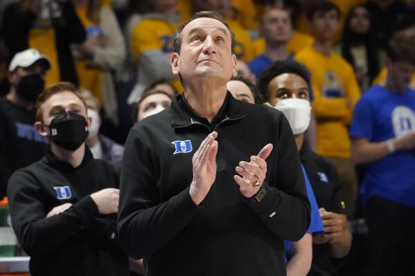 Duke coach Mike Krzyzewski applauds as he watches a video honoring him before the team's NCAA college basketball game against Pittsburgh, Tuesday, March 1, 2022, in Pittsburgh. Krzyzewski has announced his retirement at the end of the season. (AP Photo/Keith Srakocic)