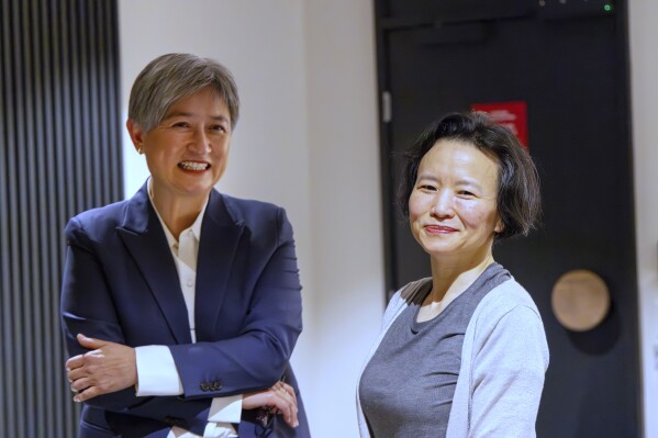 In this photo provided by the Department of Foreign Affairs and Trade, Chinese Australian journalist Cheng Lei, right, poses with Australia's Minister for Foreign Affairs, Penny Wong, at Tullamarine Airport in Melbourne, on Wednesday Oct. 11, 2023. Cheng, who was convicted on murky espionage charges and detained in China for three years has returned to Australia. (Sarah Hodges/DFAT via AP)