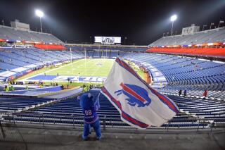 FILE - Buffalo Bills fans leave Bills Stadium as a mascot waves a flag after an NFL divisional round football game against the Baltimore Ravens, Saturday, Jan. 16, 2021, in Orchard Park, N.Y. The Bills won 17-3. Though the Buffalo Bills’ lease on their current stadium doesn’t expire for 21 more months, time is running short on the team reaching a financing agreement with public officials on its proposal to build a new facility.(AP Photo/Adrian Kraus, File)