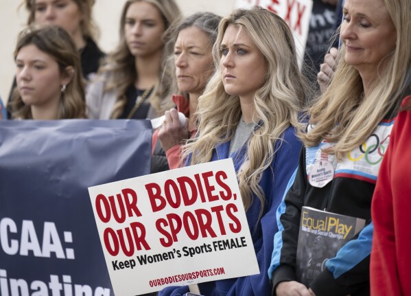 FILE - Former University of Kentucky swimmer Riley Gaines, second from right, stands during a rally on Thursday, Jan. 12, 2023, outside of the NCAA Convention in San Antonio. Gaines was among more than a dozen college athletes who filed a lawsuit against the NCAA on Thursday, March 14, 2023, accusing it of violating their Title IX rights by allowing Lia Thomas to compete at national championships in 2022. (AP Photo/Darren Abate, File)