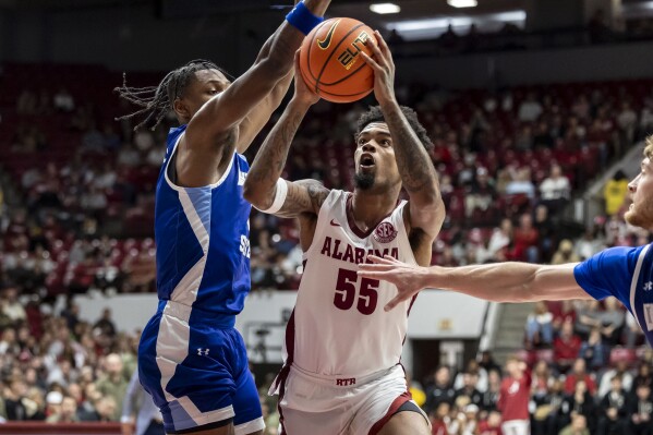 Alabama guard Aaron Estrada (55) gets by Indiana State guard Ryan Conwell, left, to shoot during the first half of an NCAA college basketball game, Friday, Nov. 10, 2023, in Tuscaloosa, Ala. (AP Photo/Vasha Hunt)