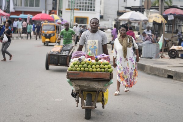 A man wheels a barrow with lemons on the streets of Lagos, Nigeria, Tuesday, Sept. 5, 2023. Made up of hundreds of thousands of members, the Nigeria Labor Congress workers association began Tuesday a two-day “warning strike,” in protest of the growing cost of living due to the removal of gas subsidies, threatening to “shut down” Africa’s largest economy if their demands for improved welfare are not met. their second in over a month. (AP Photo/Sunday Alamba)