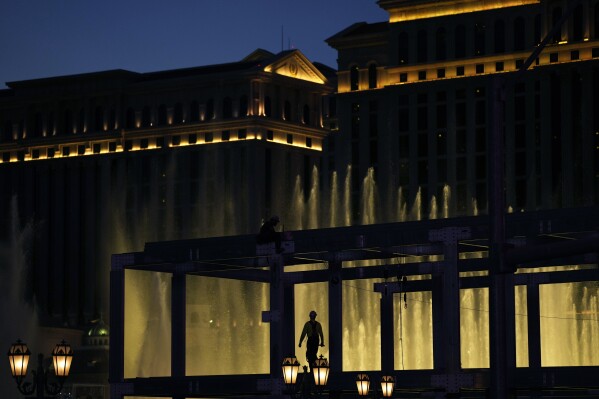 A construction worker helps build a grandstand in front of the fountains at Bellagio hotel-casino along the Las Vegas Strip ahead of the Las Vegas Formula One Grand Prix auto race Tuesday, Sept. 19, 2023, in Las Vegas. (AP Photo/John Locher)