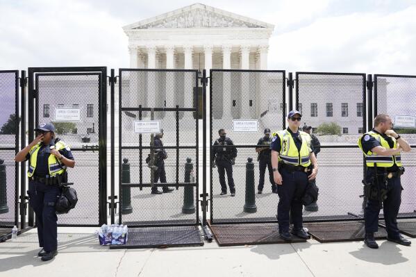Authorities stand guard by a fence outside the Supreme Court following Supreme Court's decision to overturn Roe v. Wade in Washington, Friday, June 24, 2022. The Supreme Court has ended constitutional protections for abortion that had been in place nearly 50 years, a decision by its conservative majority to overturn the court's landmark abortion cases.(AP Photo/Jacquelyn Martin)