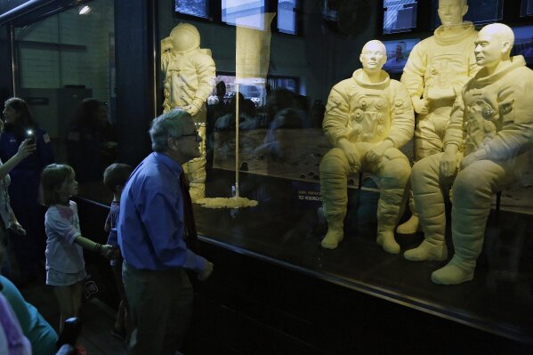 Ohio Gov. Mike DeWine takes his grandchildren Steven Dudukovich, 6, and Jean Dudukovich, 8, to see the butter sculptures of astronauts Neil Armstrong, Buzz Aldrin and Michael Collins in the Dairy Products Building inside the Ohio State Fair in Columbus, Ohio, after the opening on Wednesday, July 24, 2019. (Kyle Robertson/The Columbus Dispatch via AP)