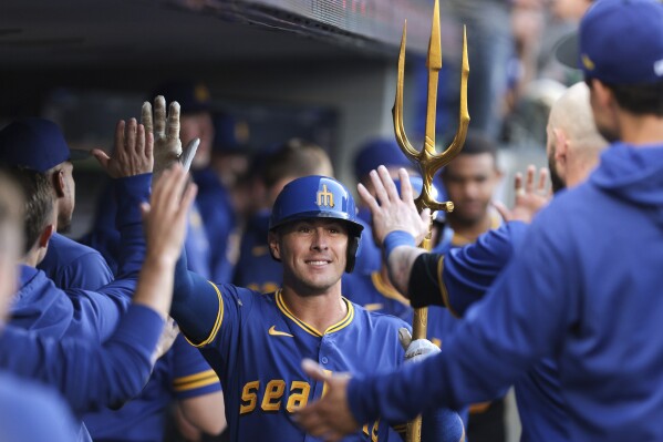 Seattle Mariners' Dylan Moore celebrates in the dugout after his two-run home run during the fourth inning of a baseball game against the Oakland Athletics, Friday, May 10, 2024, in Seattle. (AP Photo/Jason Redmond)