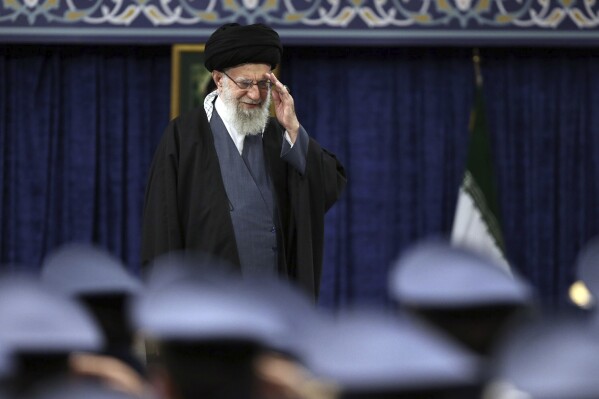 In this photo released by the office of the Iranian supreme leader, Supreme Leader Ayatollah Ali Khamenei salutes during a meeting with army's air force and air defense staff, in Tehran, Iran, Monday, Feb. 5, 2024. (Office of the Iranian Supreme Leader via AP)