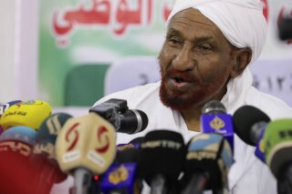 FILE - In this Feb. 6, 2020 file photo, former Sudanese Prime Minister Sadiq al-Mahdi, left, leader of the Umma political party speaks during a news conference in Khartoum, Sudan. Al-Mahdi has slammed an announcement by President Donald Trump that Sudan would start normalizing ties with Israel. Al-Mahdi said Saturday, Oct. 24, the announcement “contributes to the elimination of the peace project in the Middle East and to preparing for the ignition of a new war.” (AP Photo/Marwan Ali, File)