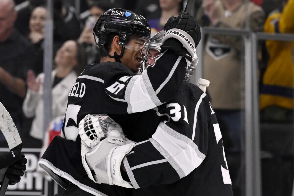 Los Angeles Kings right wing Quinton Byfield, left, hugs goaltender David Rittich after the Kings defeated the Edmonton Oilers in an NHL hockey game in Los Angeles, Saturday, Feb. 10, 2024. (AP Photo/Alex Gallardo)
