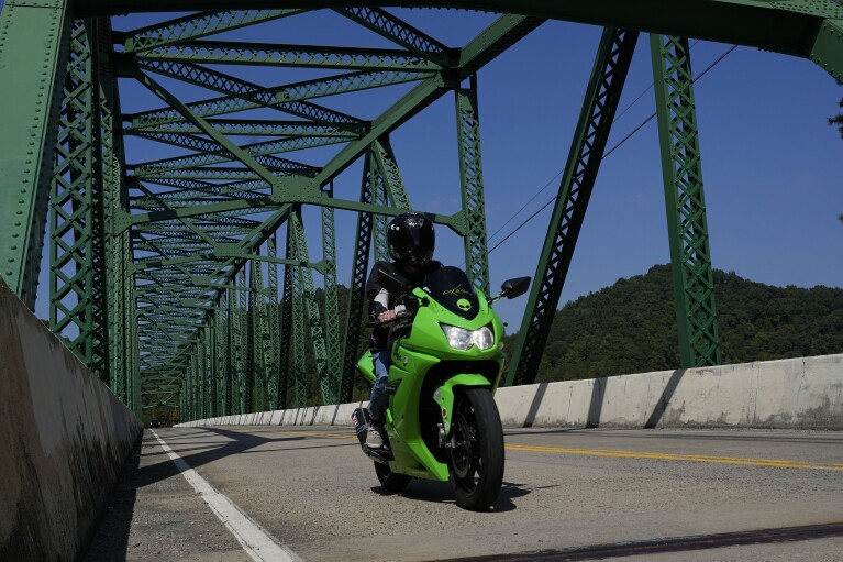 Karen Goodwin rides her motorcycle along U.S. Highway 421, also known as The Snake, Friday, Sept. 22, 2023, in Shady Valley, Tenn. Goodwin's son, Austin Hunter Turner, died in 2017 after an encounter with the Bristol Police Department. (AP Photo/George Walker IV)
