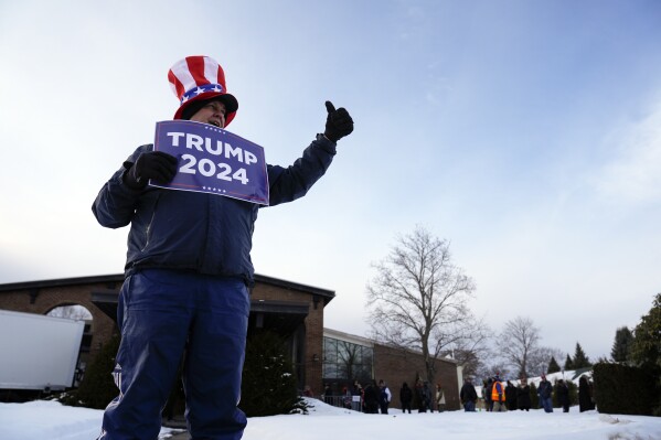 Un partidario del candidato presidencial republicano, el expresidente Donald Trump, le hace un gesto a un automovilista antes de un evento de campaña en Laconia, NH, el lunes 22 de enero de 2024. (Foto AP/Matt Rourke)