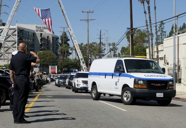 A procession honoring Manhattan Beach Officer Chad Swanson arrives at the Los Angeles County Coroner's office on Wednesday, Oct. 4, 2023. Swanson, who was a hero of the 2017 Las Vegas mass shooting, died Wednesday when his motorcycle was hit by a car on a Los Angeles-area highway, authorities said. (Dean Musgrove/The Orange County Register via AP)