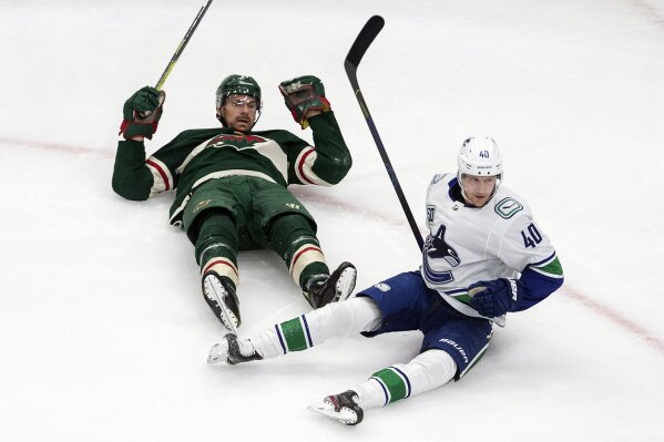 Minnesota Wild's Marcus Foligno (17) and Vancouver Canucks' Elias Pettersson (40) react after colliding during second-period NHL hockey game action in Edmonton, Alberta, Thursday, Aug. 6, 2020. (Jason Franson/The Canadian Press via AP)