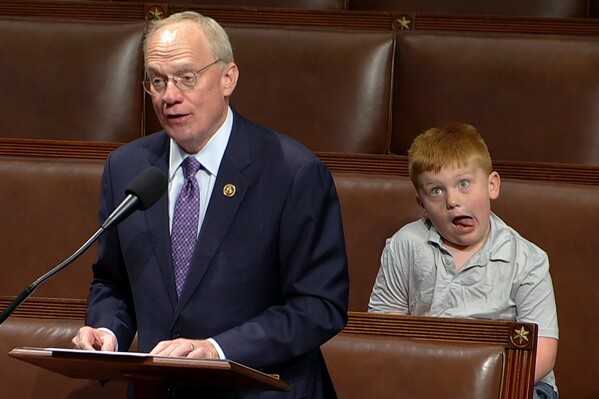This image from House Television shows Rep. John Rose, R-Tenn., speaking on the floor of the House of Representatives Monday, June 3, 2024, in Washington, as his son Guy makes a face. (House Television via AP)