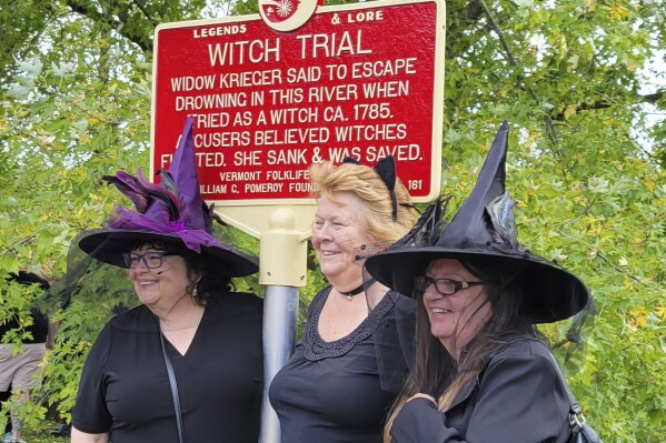 In this Sept. 16, 2023 photo, provided by Alexina Jones, people dressed as witches gather near a newly installed marker, in Pownal, Vt., that recognizes the survivor of Vermont's only recorded witch trial. Widow Krieger was said to have escaped drowning in the Hoosic River when tried as a witch in 1785, according to the Legends and Lore marker. (Alexina Jones via AP)