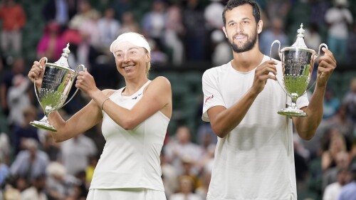 Croatia's Mate Savic, right, and Ukraine's Lyudmyla Kichenok celebrate with their trophies after beating Belgium's Joran Vliegen and China's Xu Yifan to win the final of the mixed doubles on day eleven of the Wimbledon tennis championships in London, Thursday, July 13, 2023. (AP Photo/Alberto Pezzali)