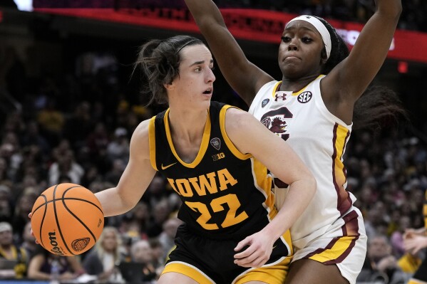 Iowa guard Caitlin Clark (22) drives around South Carolina guard Raven Johnson (25) during the second half of the Final Four college basketball championship game in the women's NCAA Tournament, Sunday, April 7, 2024, in Cleveland. (AP Photo/Morry Gash)