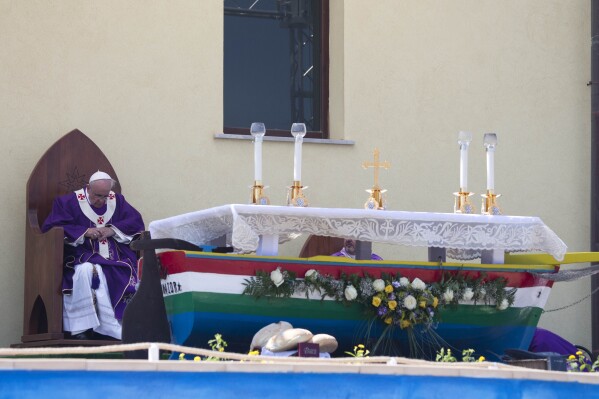 Pope Francis celebrates a Mass in front of an altar made with recycled wood from a broken migrant boat, during his visit to the island of Lampedusa, southern Italy, July 8, 2013. (AP Photo/Alessandra Tarantino)