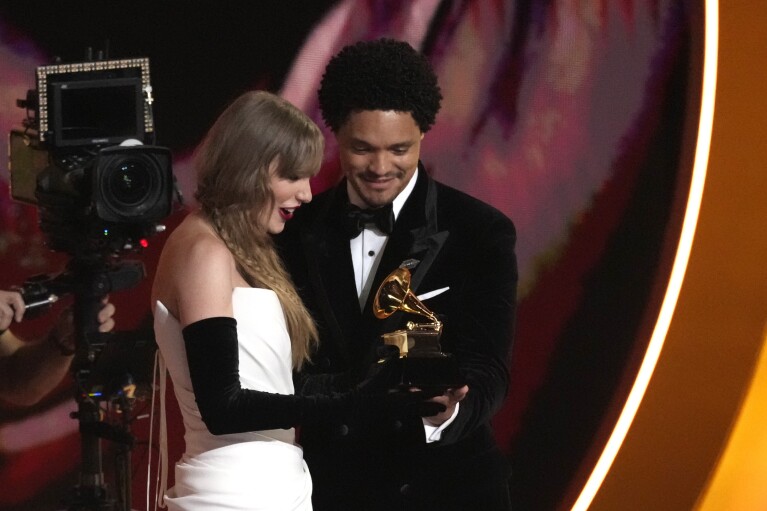 Host Trevor Noah, right, presents Taylor Swift with the award for best pop vocal album for 
