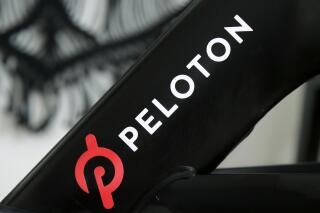 FILE - This Nov. 19, 2019 file photo shows a Peloton logo on the company's stationary bicycle in San Francisco.   Peloton is recalling its treadmills after one child died and 29 other children suffered from cuts, broken bones and other injuries from being pulled under the rear of the treadmill. The U.S. Consumer Product Safety Commission said Wednesday, May 5, 2021,  that Peloton received 72 reports of adults, kids, pets or other items, such as exercise balls, being pulled under the treadmill.  (AP Photo/Jeff Chiu, File)