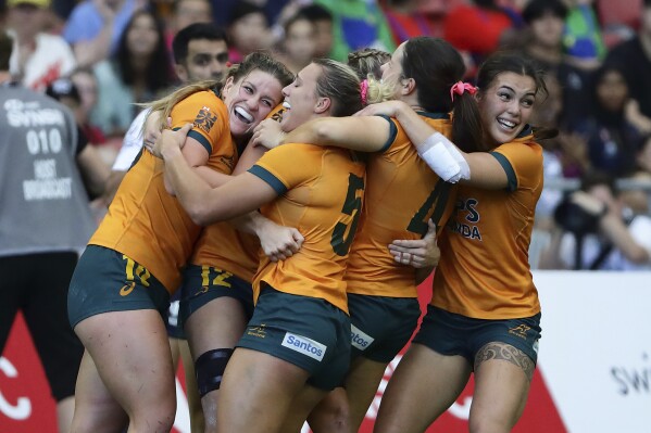 Australian players celebrate after defeating France in the HSBC World Rugby Sevens Series 2024 Women's Cup semi-final match between Australia and France in Singapore on Sunday, May 5, 2024. (AP Photo/Suhaimi Abdullah)