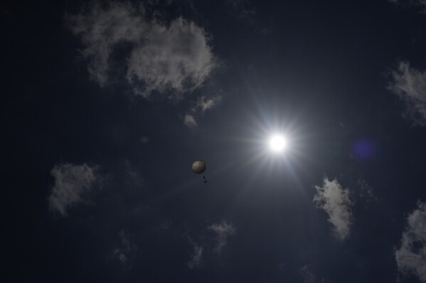 A weather balloon soars in the sky that was released by members of Project ICECHIP's black team to collect data Friday, June 6, 2025, in Morton, Texas. (AP Photo/Carolyn Kaster)