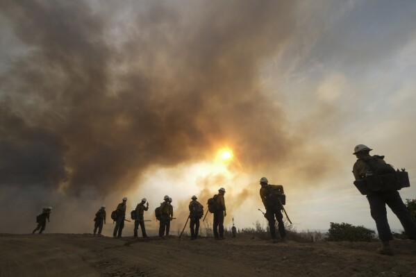 FILE - Firefighters watch as the Fairview Fire burns on a hillside, Sept. 8, 2022, near Hemet, Calif. (AP Photo/Ringo H.W. Chiu, File)