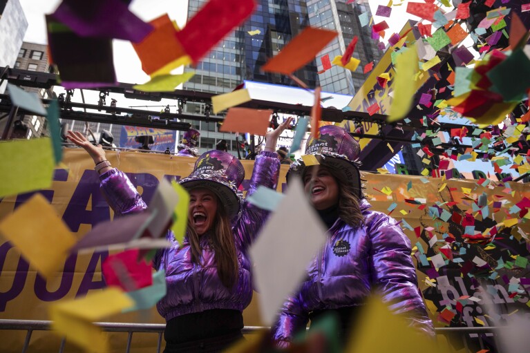 People throw confetti during a confetti test ahead of New Year's Eve in Times Square, Friday, Dec. 29, 2023, in New York. (AP Photo/Yuki Iwamura)